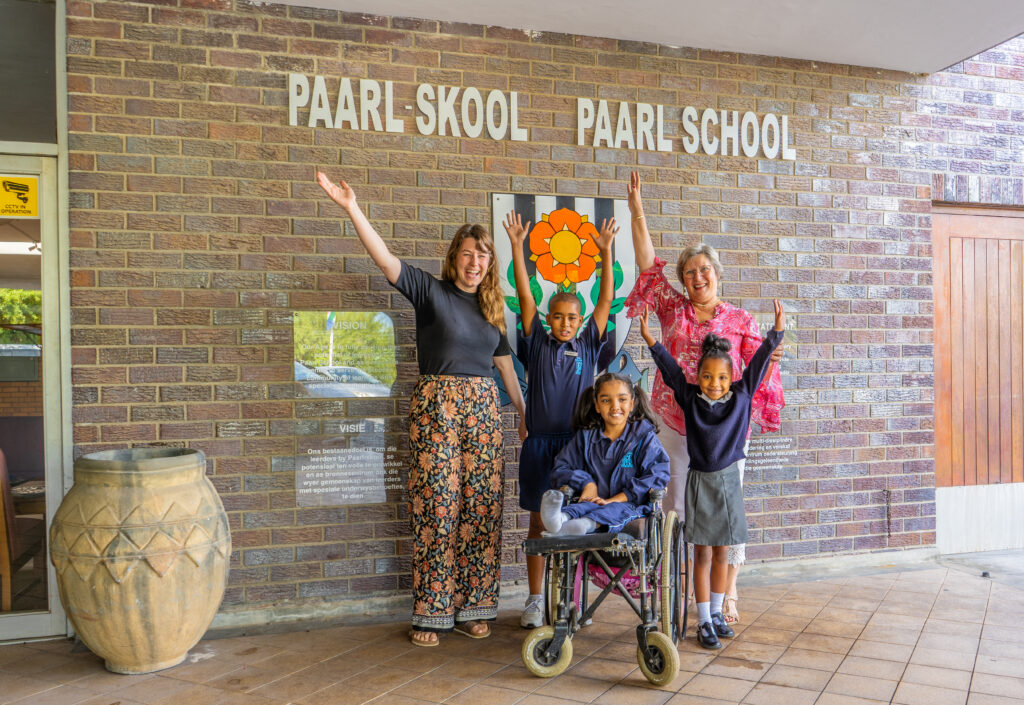 Kinder und Erwachsene vor dem Eingang der Paarl School in Südafrika