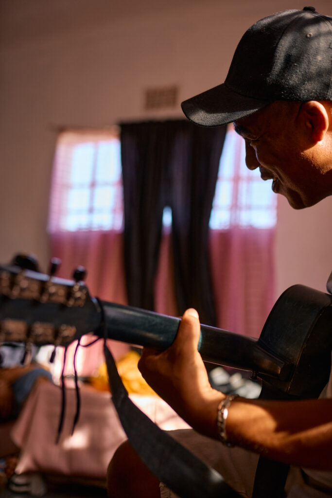 Person spielt Gitarre in einem Unterrichts- oder Gemeinschaftsraum